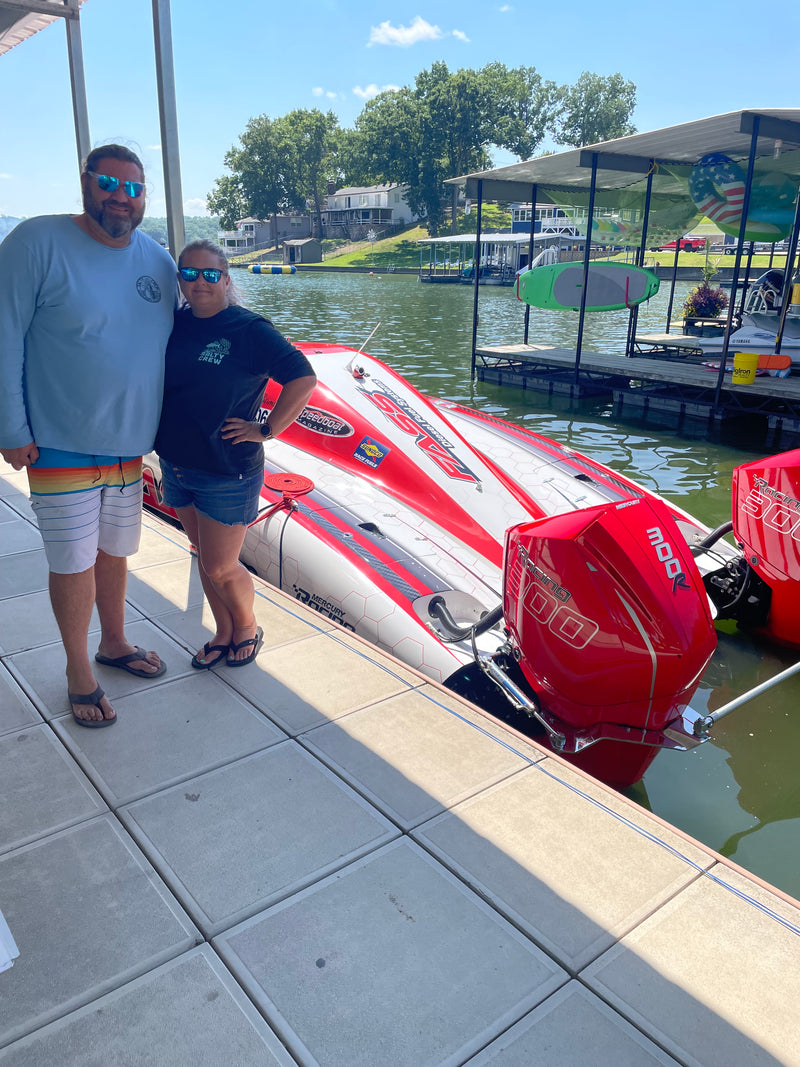 Lake of the Ozark shootout. Two offshore speedboat fans show off next to a power boat displayed at the Marina before competition.